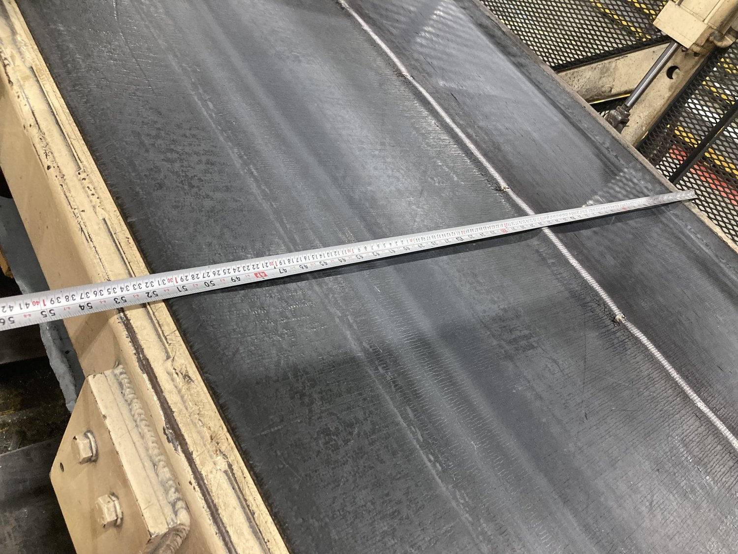 Stamped steel door skins moving along the roller conveyor into the inspection station