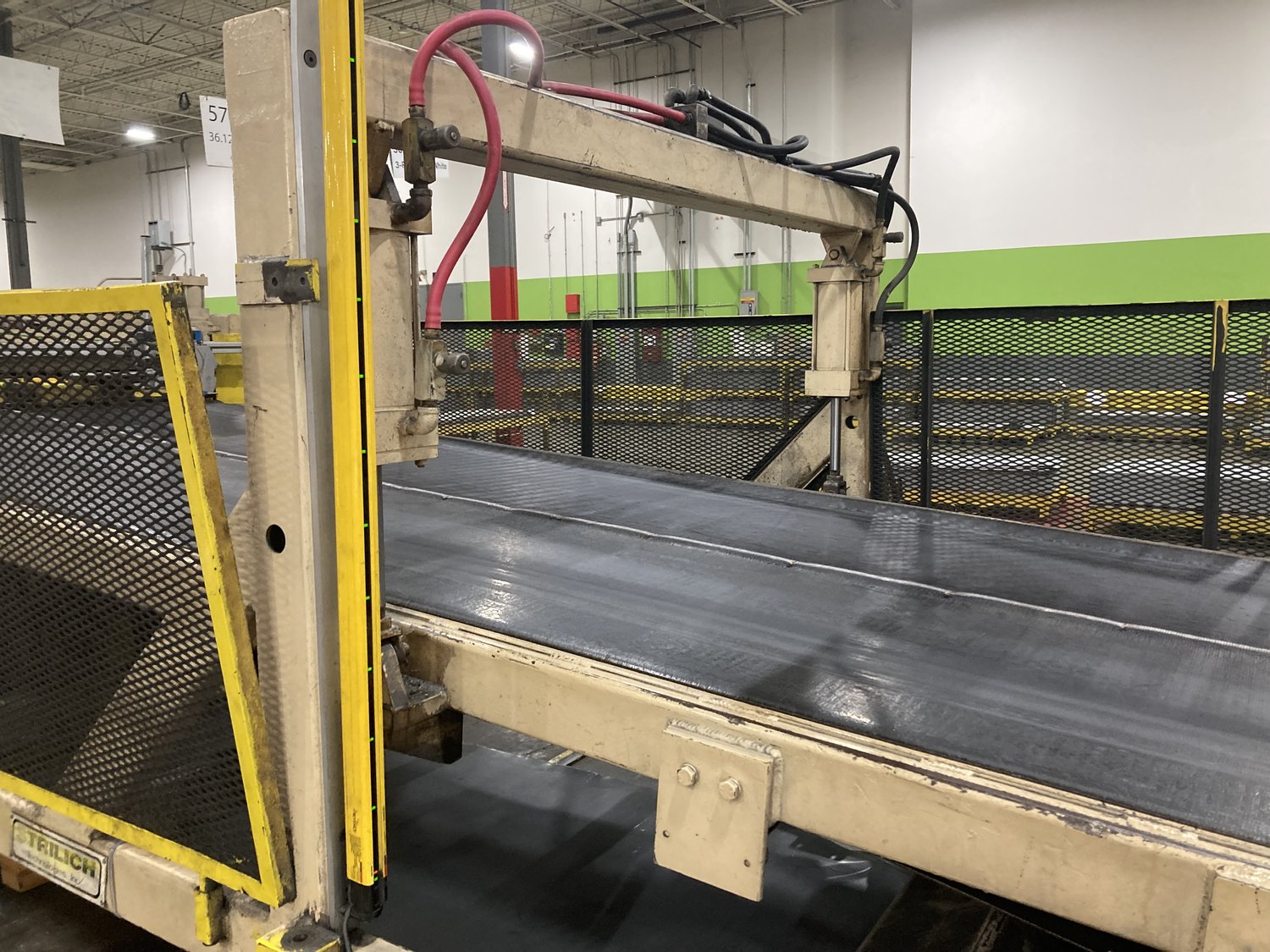Installed door-skin inspection station: camera gantry mounted over the belt conveyor at the customer plant