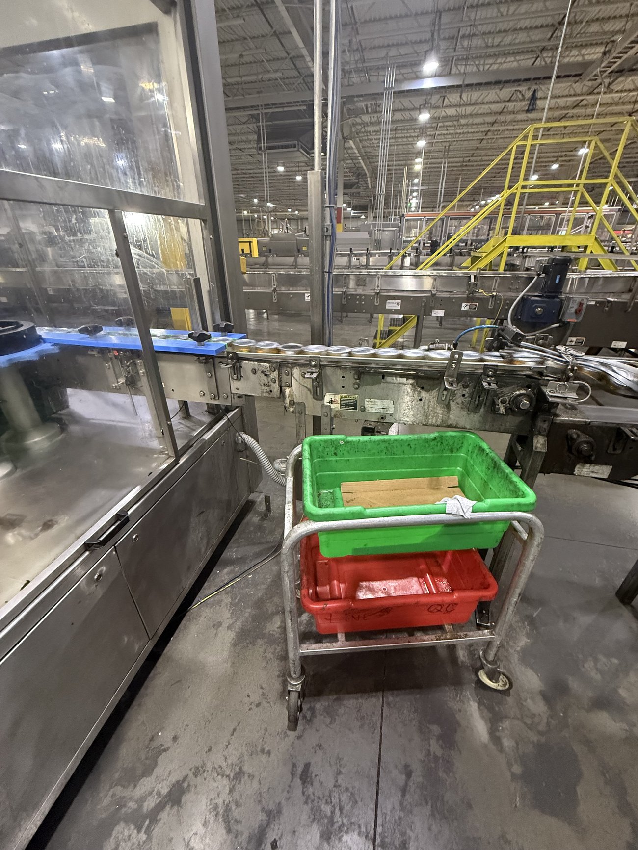 Cans running into the inspection point with pass and reject totes at the station
